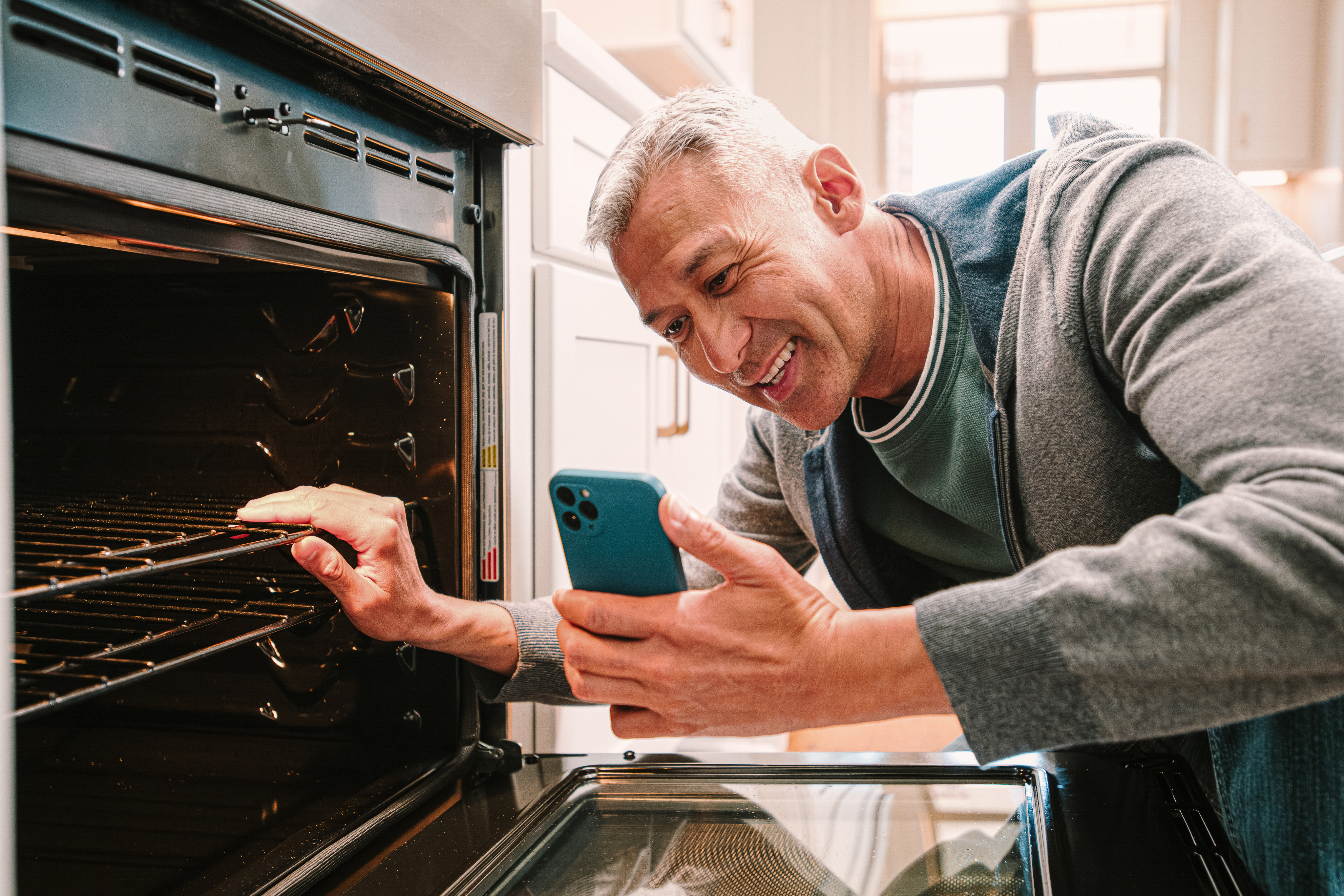 Homeowner on video chat while inspecting his oven