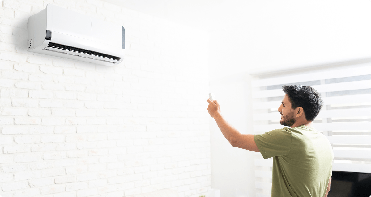 Man controlling mini split unit with remote