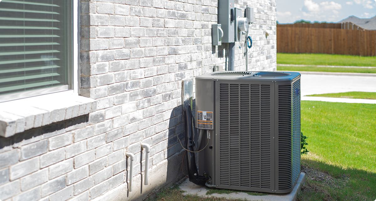 AC Unit along exterior of a brick house